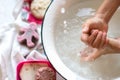 ChildÃ¢â¬â¢s hands under white bowl with water upon water stream Royalty Free Stock Photo